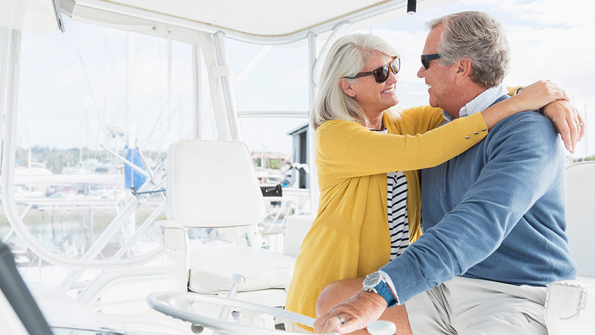 an older couple hugging on a boat