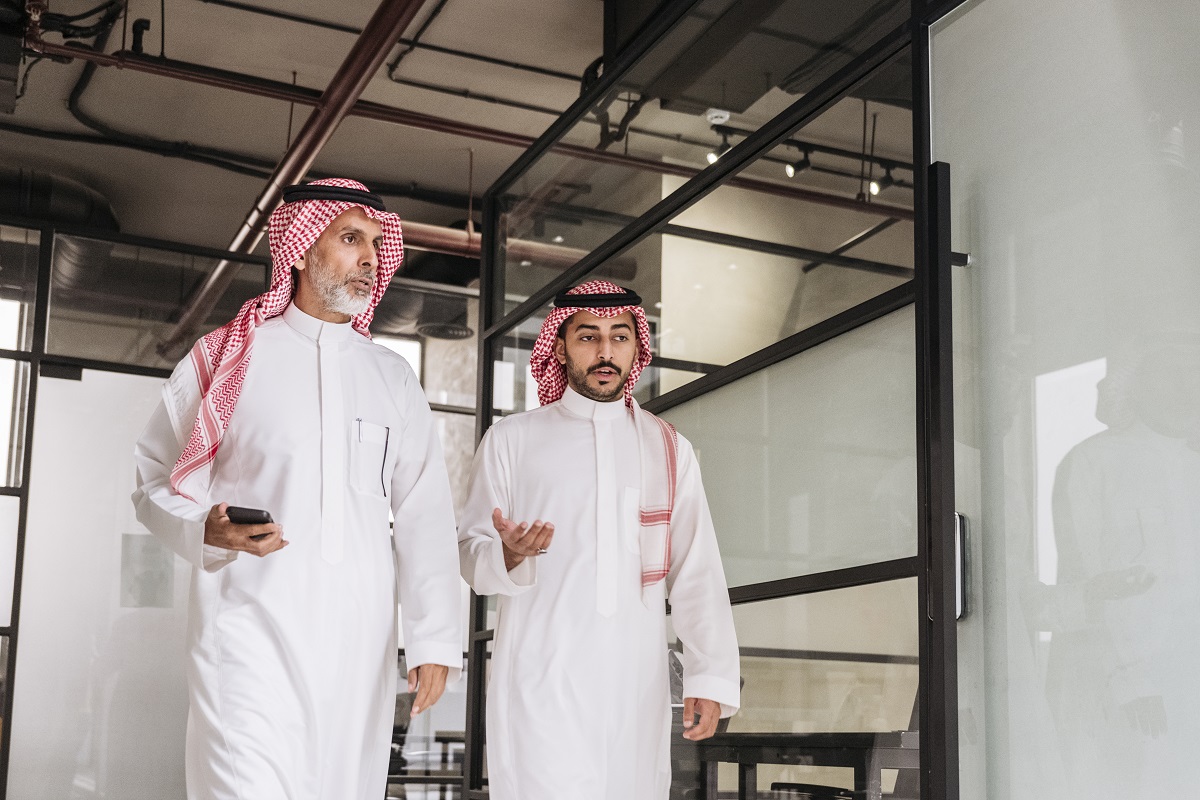 Bearded executives walking through modern Riyadh office