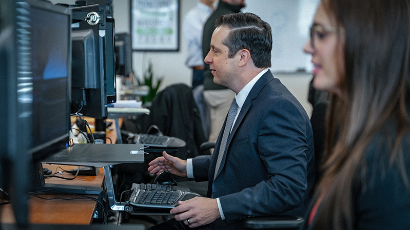Side view of businessman and businesswoman sitting at computers