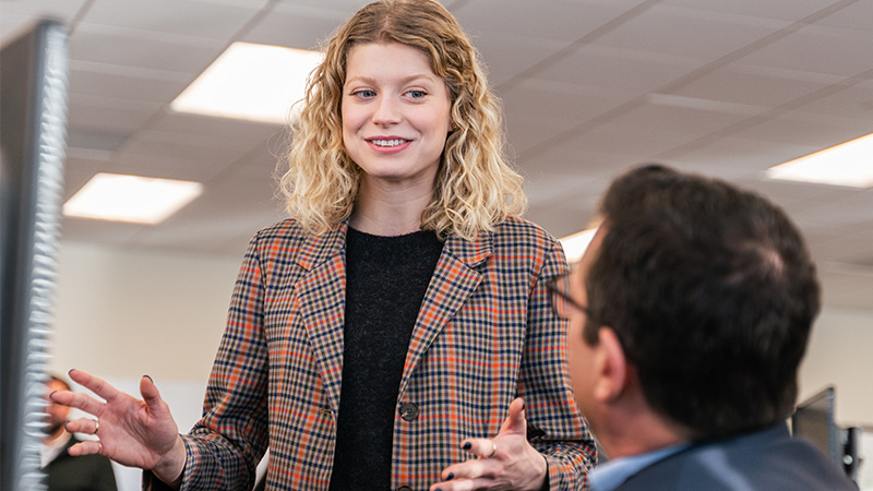 a woman speaking with her coworker