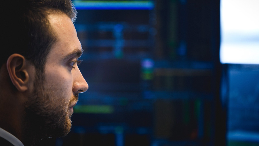 Man looking at a blue monitor