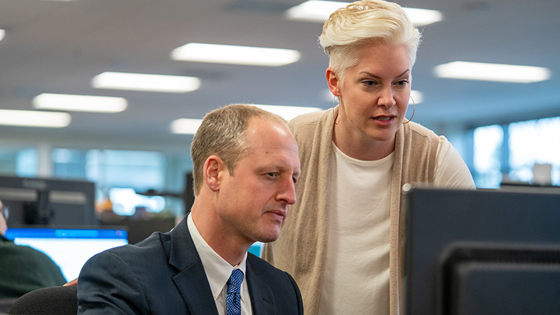 business man and business woman looking at something on the computer in the office