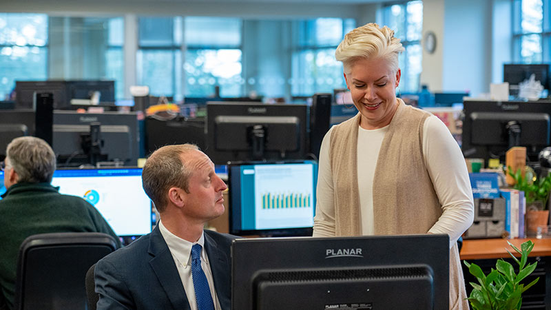 business man and business woman at a desk looking at the computer