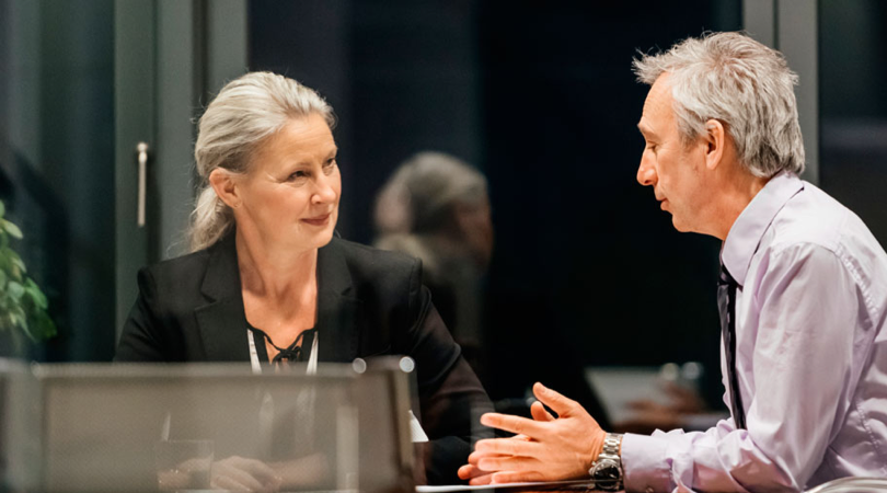 Two individuals having a discussion at a table