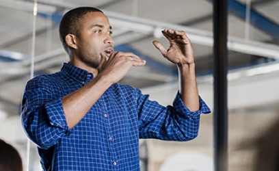 man wearing blue collered shirt is explaining something with his hands