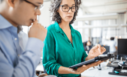 Lady holding tablet and explaining something to another person