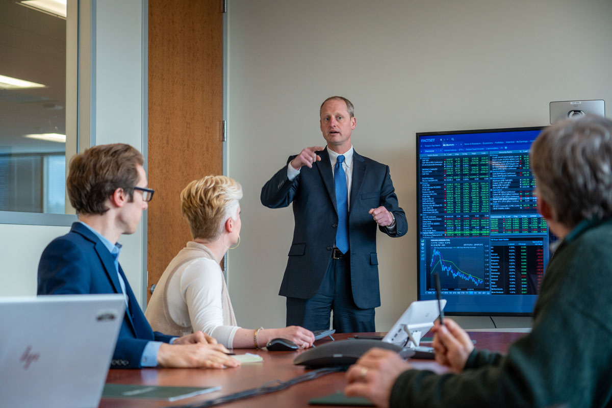 Man in suit talking to a small audience 