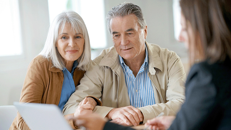 couple working with a financial advisor analyzing a financial pan and estate plan for their retirement portfolio  