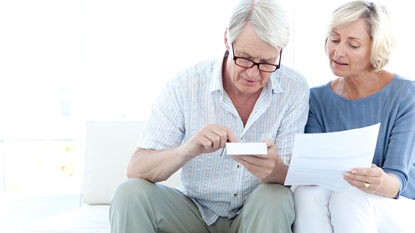 Two people having a discussion holding a report and a calculator