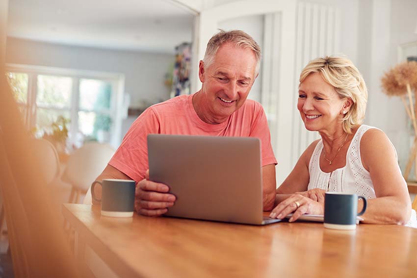 Two people working around a laptop on a table