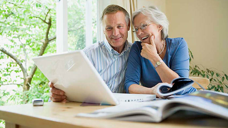older couple looking at a document at the kitchen table