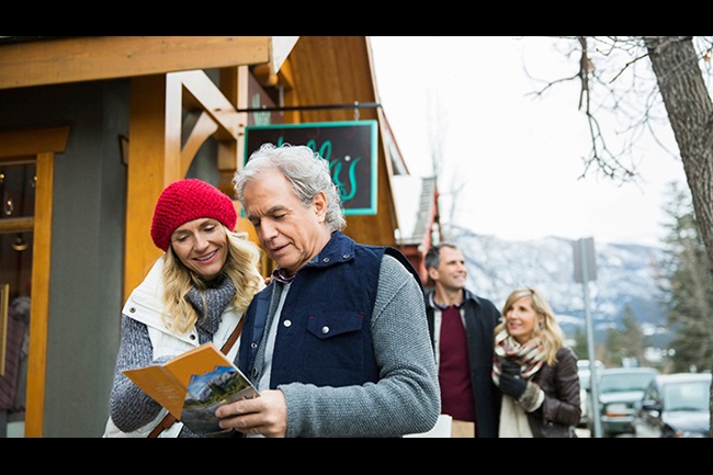 an older couple in cold weather looking at a brochure