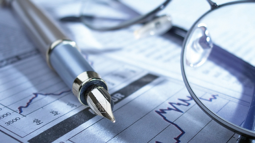 A piece of paper with two graphs a pen and a pair of glasses