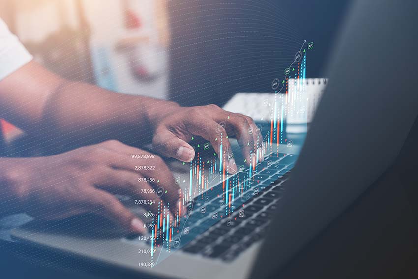 Person typing on a laptop with a chart overlay