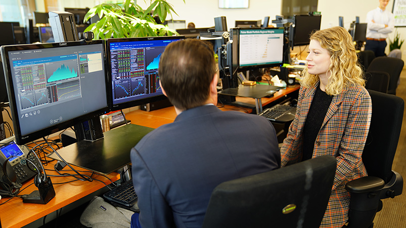 man and woman discussing charts at an office desk 