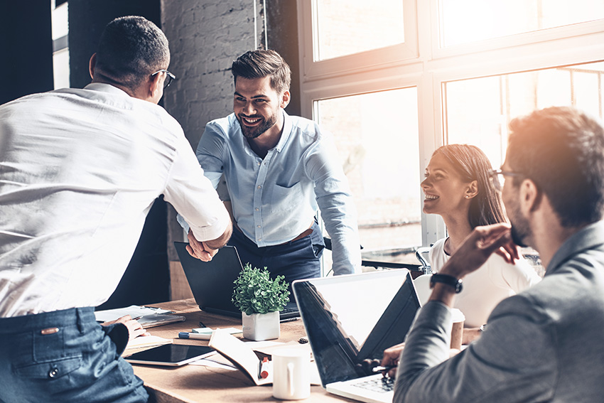 Four people collaborating around a meeting table
