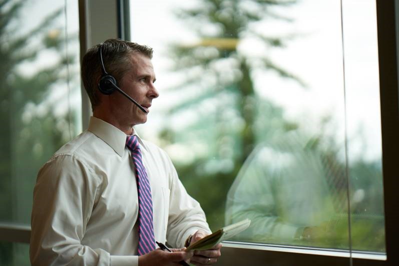 Business person talking with a headset looking out the window