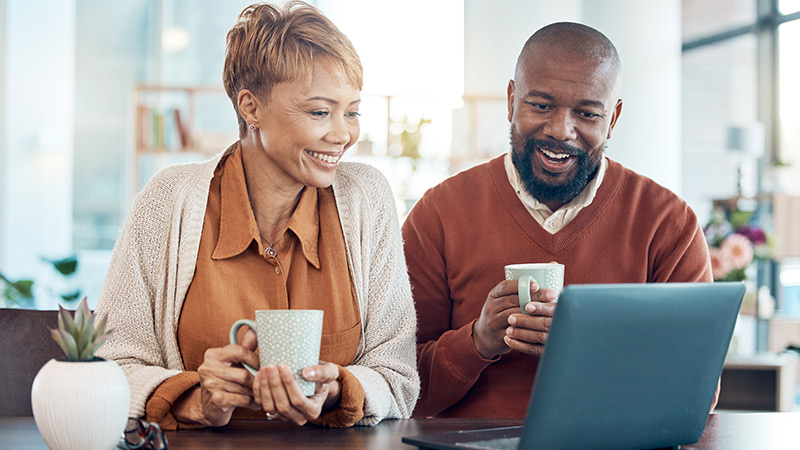 woman and man looking at a computer at their desk going over their retirement goals
