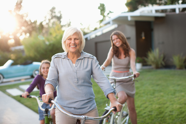 Older woman smiling while riding her bike outside