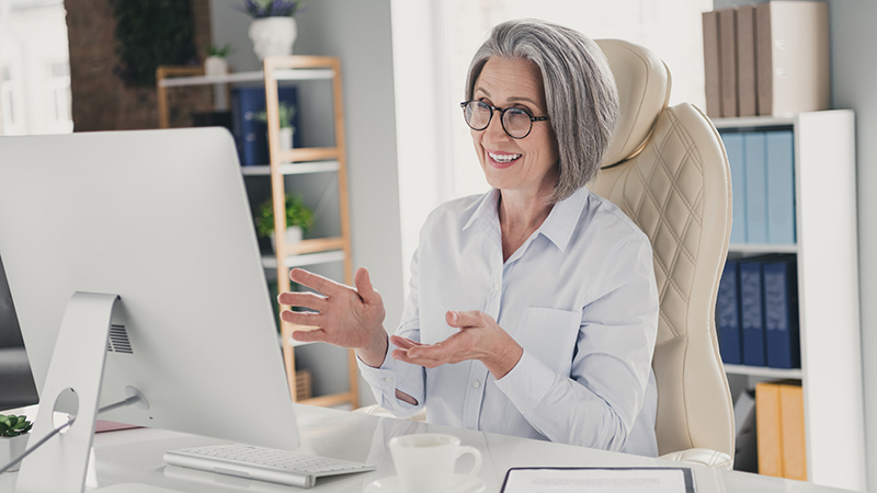 woman sitting at her desk on a laptop doing a video call