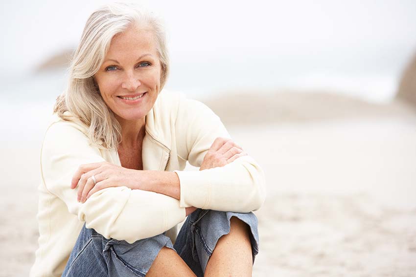 Person seated on the beach smiling