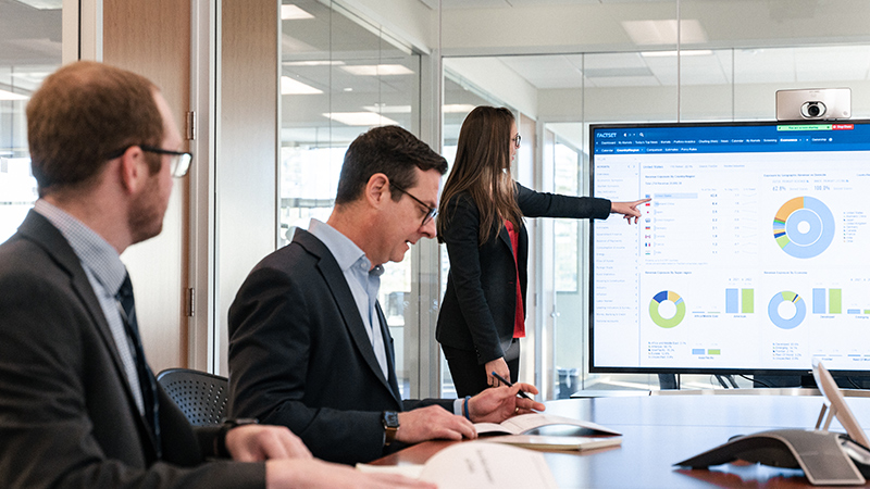 business professional doing a presentation in a conference room with others taking notes