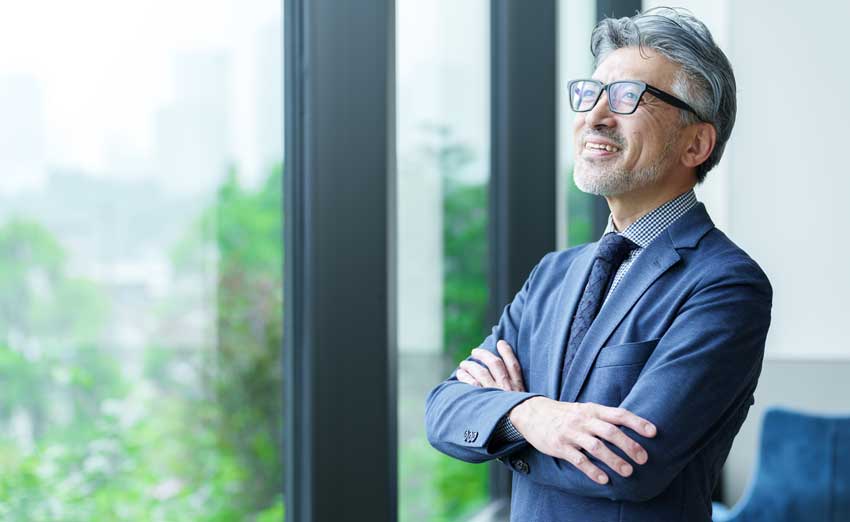 A businessman smiles, staring out the window