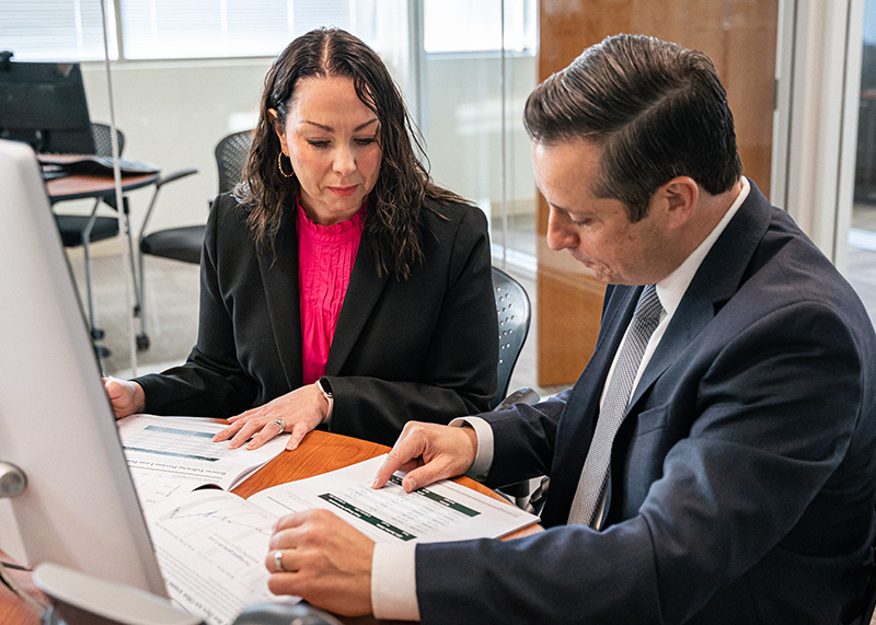 woman and man looking over charts on an office desk